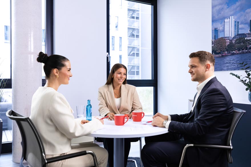 Ein Business Mann mit Brille und Sakko unterhält sich mit einer Frau. 