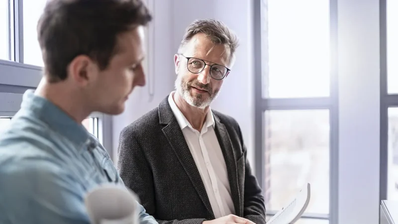 Zwei-Business-Kollegen-besprechen-Dokument_Westend61